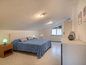 una camera da letto con un letto con un piumone blu di Holiday Home Miriam by Interhome a Marina dʼAndora