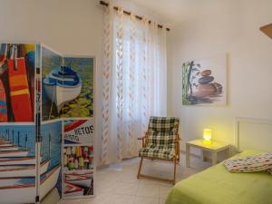 マリーナ・ディ・アンドーラにあるHoliday Home Miriam by Interhomeのベッドルーム1室(ベッド1台、椅子1脚付)