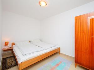 バラトンフェニヴェシュにあるHoliday Home Apricot by Interhomeの小さなベッドルーム(ベッド1台、木製キャビネット付)