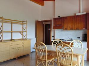 a kitchen with a wooden table and chairs in a room at Apartment Colombaro Nuovo-4 by Interhome in San Felice del Benaco