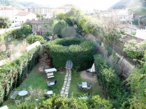 una vista aérea de un jardín con mesas y bancos en Apartment Morgana - FLG208 by Interhome en Finale Ligure