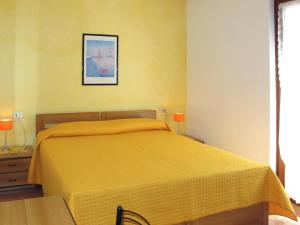 sypialnia z łóżkiem z żółtą narzutą w obiekcie Apartment Villa Rizzardi-2 by Interhome w mieście Malcesine