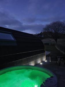 einem grünen Wasserbecken vor einem Gebäude in der Unterkunft Ribblesdale Pods in Horton in Ribblesdale