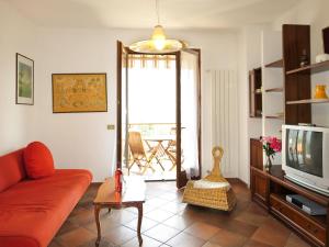 a living room with a red couch and a tv at Apartment La Rocca by Interhome in Castelveccana