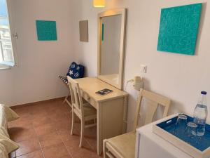 a room with a table and chairs and a mirror at A Hotel in Spetses