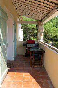um pátio exterior com uma mesa e comodidades para churrascos em Holiday Home L'Yeuse - BEF160 by Interhome em Plan Florent
