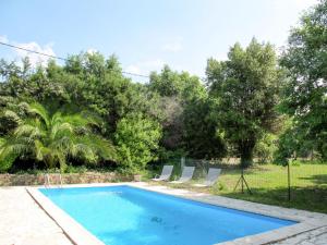 uma piscina num quintal com cadeiras e árvores em Holiday Home L'Yeuse - BEF160 by Interhome em Plan Florent