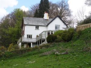 a white house on top of a hill at Lydgate House Hotel in Postbridge