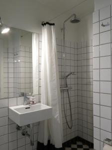 ein Bad mit einem Waschbecken und einer Dusche mit einem Duschvorhang in der Unterkunft ApartmentInCopenhagen Apartment 1159 in Kopenhagen