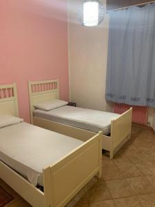two beds in a small room with a window at Appartamento Centrale in Piacenza