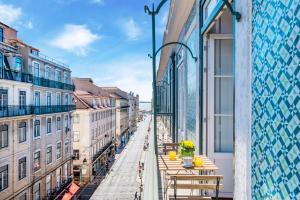 a balcony with tables and chairs on a city street at Life is Good in Lisbon Baixa in Lisbon
