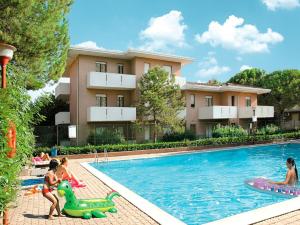 a group of children playing in a swimming pool at Apartment Orsa Maggiore by Interhome in Lignano Sabbiadoro