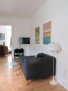 コペンハーゲンにあるApartmentInCopenhagen Apartment 1288のリビングルーム(黒いソファ、テーブル付)