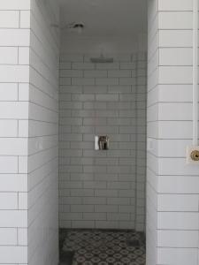 een witte betegelde douche met een toilet. bij ApartmentInCopenhagen Apartment 1290 in Kopenhagen