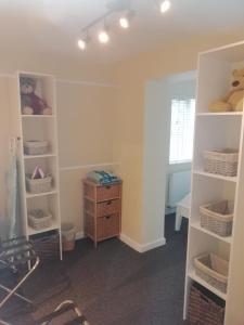 a room with white shelves and a dresser at The Studio in Georgeham