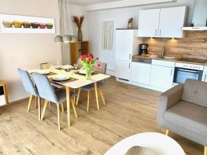 a kitchen and dining room with a table and chairs at mönchgut living & spa in Gager