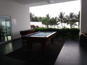 a pool table in a room with palm trees at RESORT PLAYA AZUL in Tonsupa