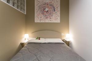 a bedroom with a large bed with two lamps at HH Hermoso Housing ALESSANDRIA in Alessandria
