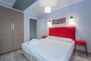 1 dormitorio con 1 cama grande y cabecero rojo en Bucharest Accommodation Apartments, en Bucarest