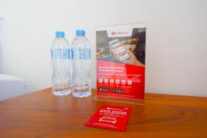 - deux bouteilles d'eau et une boîte sur une table dans l'établissement RedDoorz Plus near UMS Solo, à Solo