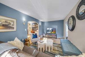 a living room with blue walls and a clock on the wall at Luxury Apartment in Historic Carriage House in Kennett Square