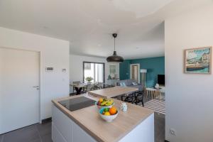 a kitchen with a table with a bowl of fruit on it at Villa Paloma in Saint-Palais-sur-Mer