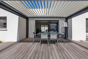 a patio with a table and chairs on a deck at Villa Paloma in Saint-Palais-sur-Mer
