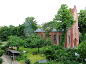 a large brick building with a garden in front of it at ApartmentInCopenhagen Apartment 1389 in Copenhagen