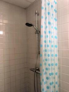 a shower with a blue and white shower curtain at ApartmentInCopenhagen Apartment 1389 in Copenhagen