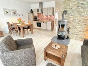 a living room with a fireplace and a dining room at mönchgut living & spa in Gager