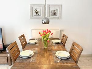 a dining room table with chairs and a vase of flowers at mönchgut living & spa in Gager