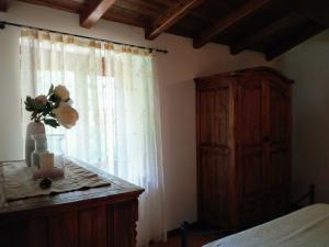 sypialnia z oknem z wazą kwiatów na stole w obiekcie Agriturismo il canale w mieście Corfino +36 zdjęć