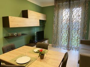 una sala da pranzo con tavolo in legno e TV di Casa di Laura mono e bilo di fronte Ospedale San Raffaele a Segrate