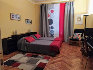 a bedroom with a bed with red pillows on it at Alma Clara B&B in Turin