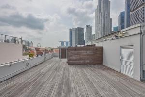 a wooden deck on a roof with a city skyline at KINN Capsule in Singapore