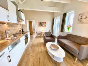a kitchen and living room with a couch and a table at mönchgut living & spa in Gager