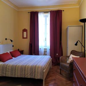 a bedroom with a bed and a window with red curtains at Alma Clara B&B in Turin