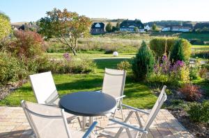 a table and chairs in a garden with a view at mönchgut living & spa in Gager