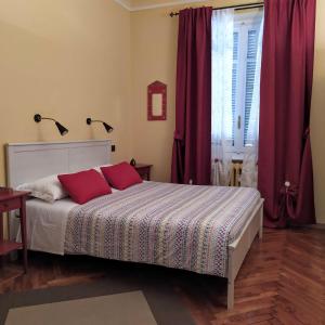 トリノにあるAlma Clara B&Bのベッドルーム1室(赤いカーテンと窓付きのベッド1台付)