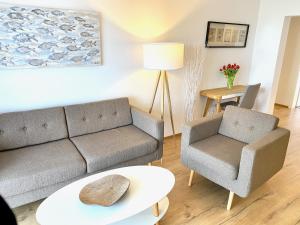 a living room with a couch and a chair at mönchgut living & spa in Gager