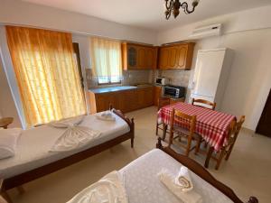 małą kuchnię z 2 łóżkami, stołem i krzesłami w obiekcie Guesthouse Mance w mieście Ksamil