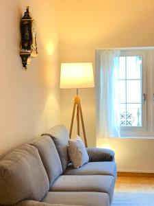 - un canapé dans le salon avec une lampe et une fenêtre dans l'établissement Old Town Loft & Central Location in Rapperswil, à Rapperswil-Jona
