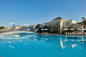a large swimming pool with chairs and umbrellas at Atlantica Aeneas Resort in Ayia Napa