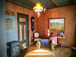a living room with red wallpaper and a wood stove at Villa Villekulla in Kristiansand