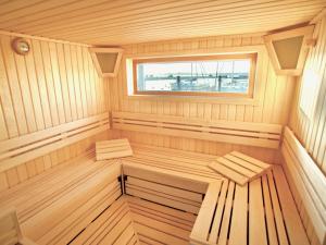 a wooden sauna with two benches and a window at mönchgut living & spa in Gager