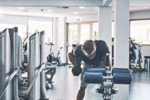 a man in a gym bending over a weight machine at Atlantica Aeneas Resort in Ayia Napa