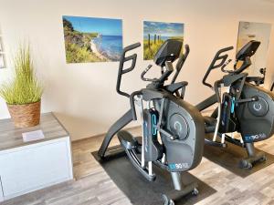 a gym with three exercise bikes in a room at mönchgut living & spa in Gager