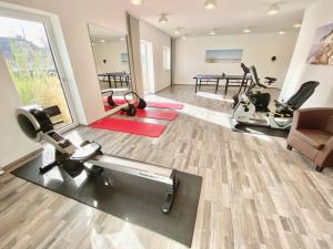 a gym with treadmills and exercise equipment in a room at mönchgut living & spa in Gager