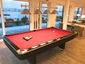 a red pool table in a room with a window at mönchgut living & spa in Gager +69 photos