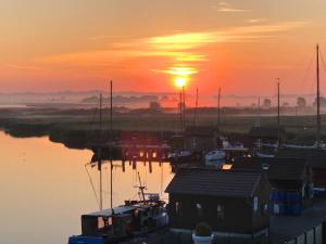 a sunset over a marina with boats in the water at mönchgut living & spa in Gager